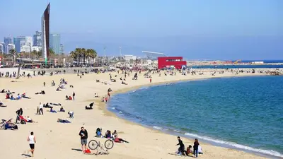 a group of people on a beach near the water at Modern apartment in Diagonal Mar in Barcelona