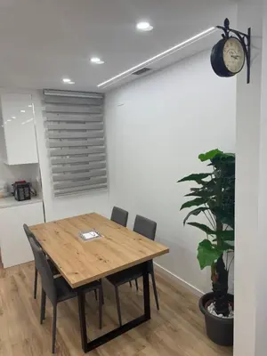 a dining room with a table and chairs and a clock at Apartamento Plaza España - Bordeta BCN in Barcelona