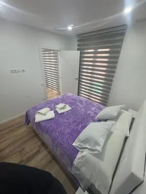 a bedroom with a bed with purple sheets and white pillows at Apartamento Plaza España - Bordeta BCN in Barcelona