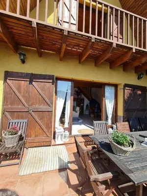 a patio with a wooden door and a table and chairs at Villa cascada in Sant Cebrià de Vallalta