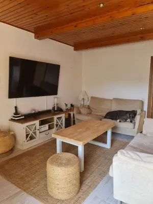 a living room with a table and a tv at Villa cascada in Sant Cebrià de Vallalta