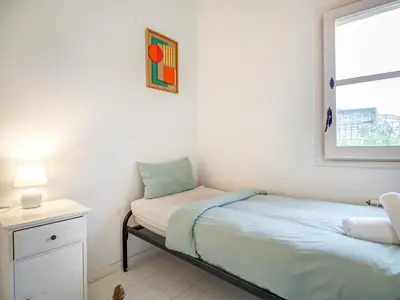 a small bedroom with a bed and a window at Masia Las Torres by Hello Homes Sitges in Sitges