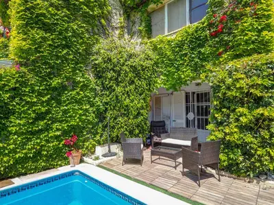 a backyard with a swimming pool and chairs and plants at Masia Las Torres by Hello Homes Sitges in Sitges