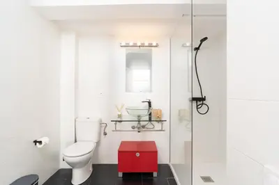 a bathroom with a toilet and a red cabinet at Dúplex Deluxe Apartment in Badalona