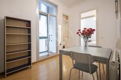 a dining room with a table and a vase of flowers at Bonito apartamento en Poble Sec in Barcelona