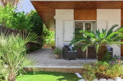 a house with a patio with a chair and plants at Marina beach Castelldefels in Castelldefels