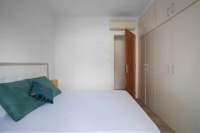 a bedroom with a white bed with a green pillow at Marina beach Castelldefels in Castelldefels