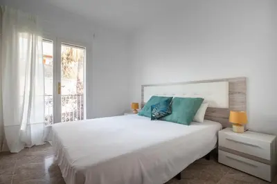a bedroom with a large white bed with blue pillows at Marina beach Castelldefels in Castelldefels