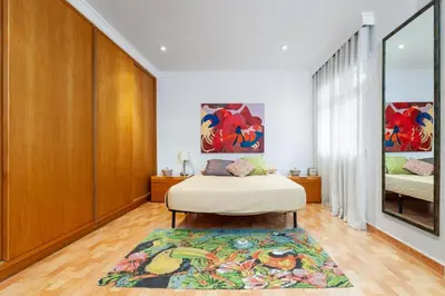 a bedroom with a bed and a rug at Villa Drago in Castelldefels