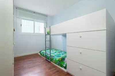 a bedroom with white drawers and a bed at Villa Drago in Castelldefels