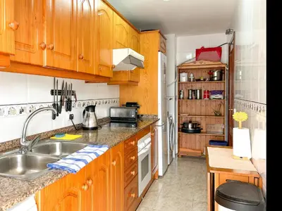 a kitchen with wooden cabinets and a sink at Apartment Rivel in Cubelles