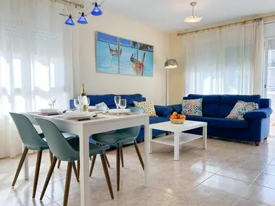 a living room with a table and a blue couch at Apartment Rivel in Cubelles