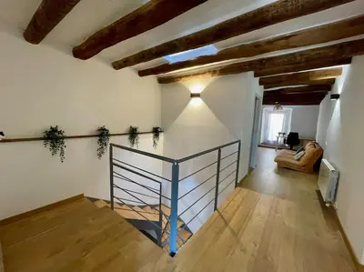 a hallway with a staircase in a room with wooden ceilings at Ca la Neus - Casa per 8 persones al poble de Mura in Mura