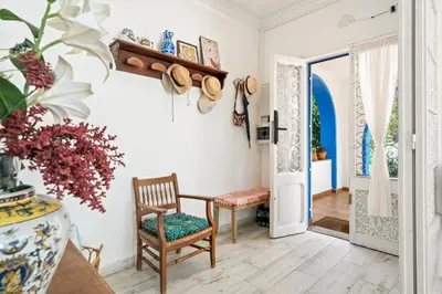a living room with a chair and a door at Atenea Room by the Beach - Claire Homes in Castelldefels