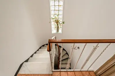 a staircase in a house with a plant in a window at Atenea Room by the Beach - Claire Homes in Castelldefels