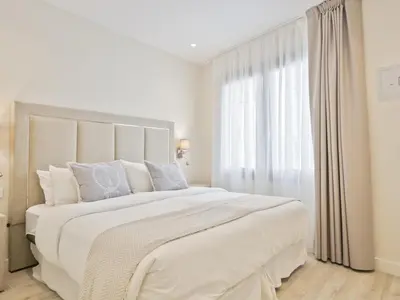 a white bedroom with a large bed and a window at Sitges Spaces Urban Beach Flat- 3 Bedrooms, 3 Bathrooms, Huge Terrace, Near Beach in Sitges
