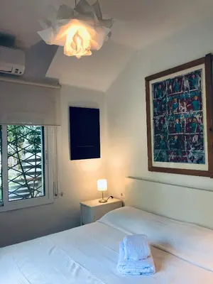 a bedroom with a white bed and a window at Pineda 38 in Gavà