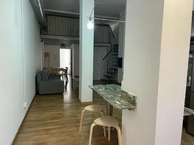 a hallway with a table and stools in a room at SA 15min downtown Barcelona, 5min Metro, Beach nearby in Sant Adria de Besos