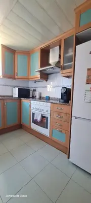 a kitchen with wooden cabinets and a white refrigerator at Alojamiento entero luminoso y bien ubicado en Terrassa Barcelona 3habitaciones 2baños in Terrassa