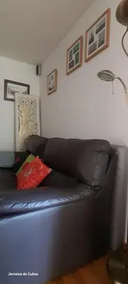 a black leather couch in a living room with a lamp at Alojamiento entero luminoso y bien ubicado en Terrassa Barcelona 3habitaciones 2baños in Terrassa