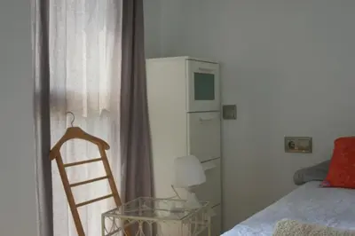 a bedroom with a chair and a table and a bed at Alojamiento entero luminoso y bien ubicado en Terrassa Barcelona 3habitaciones 2baños in Terrassa