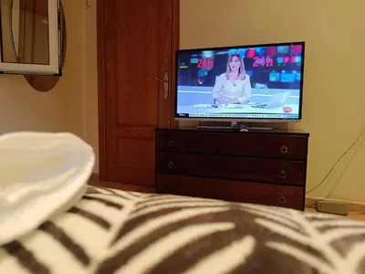 a tv sitting on a dresser in a bedroom at Habitación y baño privado in Vilanova del Camí