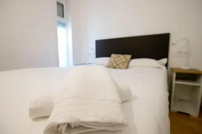 a white bed with white sheets and pillows at Panoramic view Gavà Mar in Gavà