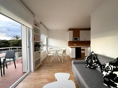 a living room and kitchen with a couch and a table at Panoramic view Gavà Mar in Gavà
