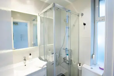 a bathroom with a glass shower and a sink at Panoramic view Gavà Mar in Gavà