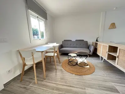 a living room with a table and chairs and a couch at Beautiful renovated studio in Castelldefels