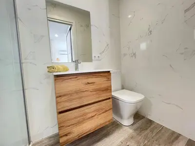 a bathroom with a toilet and a sink and a mirror at Beautiful renovated studio in Castelldefels