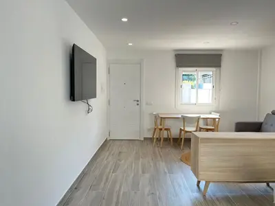 a living room with a television and a table at Beautiful renovated studio in Castelldefels