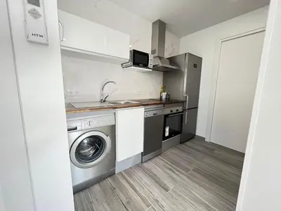a kitchen with a washing machine and a sink at Beautiful renovated studio in Castelldefels