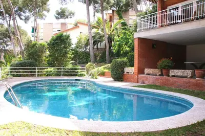a swimming pool in a yard next to a building at VILLA Mar y Montaña in Castelldefels