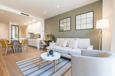 a living room with a white couch and a table at CATERINA Bac de Roda in Barcelona