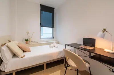 a room with a bed and a desk and a computer at CATERINA Bac de Roda in Barcelona