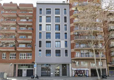 a tall white building in front of some buildings at CATERINA Bac de Roda in Barcelona