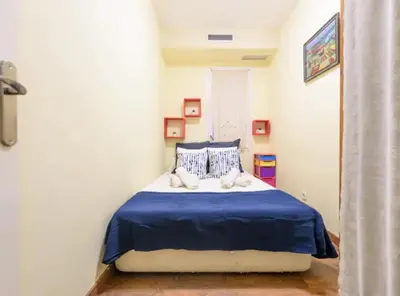 a bedroom with a bed with a blue blanket at Ramblas Rentals Spacious & Design 4Br Flat With Balcony 15m Ramblas in Barcelona