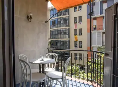 a balcony with a table and chairs and a building at Ramblas Rentals Spacious & Design 4Br Flat With Balcony 15m Ramblas in Barcelona