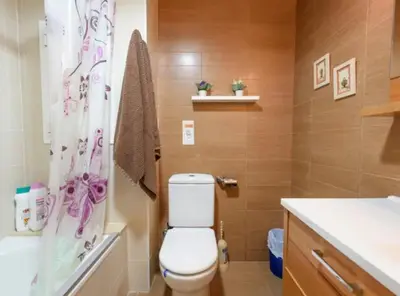 a bathroom with a toilet and a shower curtain at Ramblas Rentals Spacious & Design 4Br Flat With Balcony 15m Ramblas in Barcelona