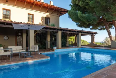 a swimming pool in front of a house at El Mirador Esencia Mediterránea in Arenys de Mar