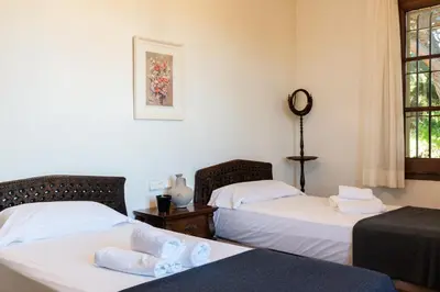 two beds in a room with white walls and windows at El Mirador Esencia Mediterránea in Arenys de Mar