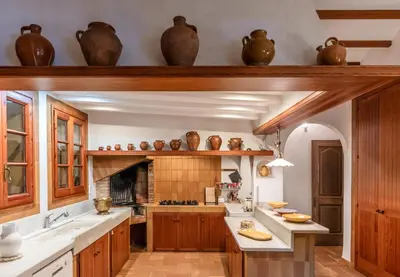 a kitchen with wooden cabinets and white counter tops at El Mirador Esencia Mediterránea in Arenys de Mar