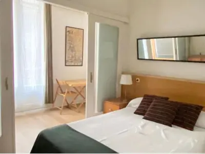 a bedroom with a bed with a mirror and a table at Piso Riera in Barcelona