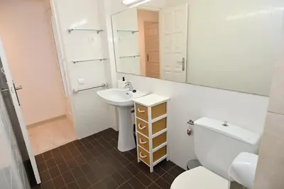 a bathroom with a sink and a toilet and a mirror at Apartamento con piscina en Sant Pol de Mar in San Pol de Mar
