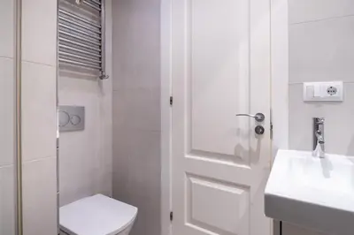 a white bathroom with a toilet and a sink at Spacious and elegant oasis in the best location, Eixample Barcelona in Barcelona