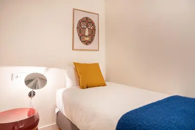 a bedroom with a bed and a table and a picture at Spacious and elegant oasis in the best location, Eixample Barcelona in Barcelona