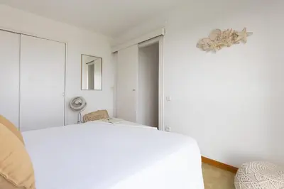 a white bedroom with a bed and a fan at Bright Apartment In Gava Mar in Gavà
