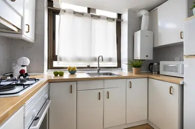 a kitchen with white cabinets and a sink at Bright Apartment In Gava Mar in Gavà