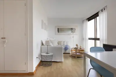 a white living room with a couch and a table at Bright Apartment In Gava Mar in Gavà